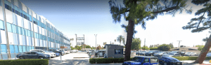Side view of the medical office building with an adjacent outdoor parking lot filled with vehicles.